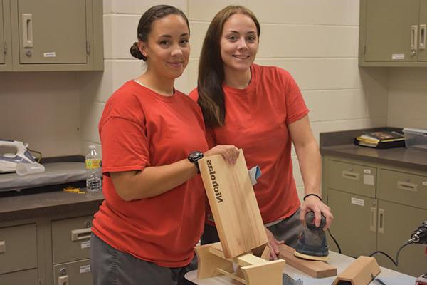 两个女人在教室里做木头项目