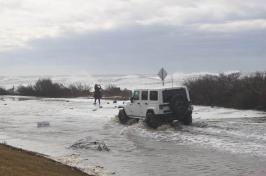 吉普车在被洪水淹没的沿海道路上行驶.