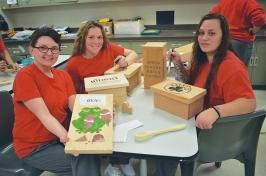 三个女人在教室里展示她们的木工作品
